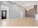 Open living room with neutral tile flooring, arched doorways, and a stylish brick accent wall at 13046 Island Breeze Ct, Orlando, FL 32824