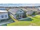 Aerial view of a well-maintained single-story home with solar panels, a front porch, and lush green lawn at 13333 Beebe Aly, Orlando, FL 32827