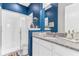 Stylish bathroom with navy blue walls, granite countertop vanity, and walk-in shower with white tiles at 13333 Beebe Aly, Orlando, FL 32827