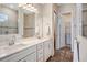 Bathroom featuring a double sink vanity, wood-look flooring, and a walk-in closet at 13348 Panama Beach Ct, Orlando, FL 32827