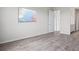 Minimalist bedroom with wood-look floors, white walls, and a large mounted television at 13348 Panama Beach Ct, Orlando, FL 32827