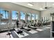 Bright fitness center with treadmills, bikes, and large windows overlooking palm trees and pool at 13348 Panama Beach Ct, Orlando, FL 32827