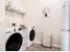 Bright laundry room featuring a washer, dryer, storage and shelving at 13348 Panama Beach Ct, Orlando, FL 32827