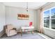 Bright home office with large window, gray floors, modern desk, and comfy chair at 13348 Panama Beach Ct, Orlando, FL 32827