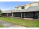 Townhouse featuring a screened-in porch and well-maintained lawn in a residential neighborhood at 15 Silver Park Cir, Kissimmee, FL 34743