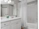 All-white bathroom with vanity, mirror, and shower-tub combo at 15848 Autumn Glen Ave, Clermont, FL 34714