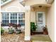 Inviting home entrance with decorative plants, window and a glass front door at 15848 Autumn Glen Ave, Clermont, FL 34714