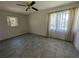 Bright bedroom featuring tile flooring, a ceiling fan, and two windows for natural light at 161 Randia Dr, Orlando, FL 32807