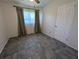 Bedroom featuring tiled floors and a window providing natural light, paired with neutral walls at 161 Randia Dr, Orlando, FL 32807