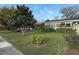 Well-maintained front yard with mature trees and lush landscaping surrounding the charming single-story home at 161 Randia Dr, Orlando, FL 32807