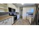 Efficient kitchen layout with stainless steel appliances, white cabinetry, and tile floor at 161 Randia Dr, Orlando, FL 32807