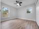 Bright bedroom featuring two windows, a ceiling fan and light wood flooring at 1625 Victory Palm Dr, Edgewater, FL 32132