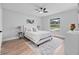 Bright bedroom featuring a queen-sized bed, ceiling fan and a window overlooking the front yard at 1625 Victory Palm Dr, Edgewater, FL 32132