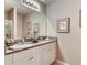 Bathroom featuring double sinks with granite countertop, framed mirror, and vanity with white cabinets at 1648 Badger Creek Rd, Kissimmee, FL 34744