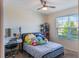 Bright bedroom with a tufted bed, vanity desk, ceiling fan, and a sunny window view at 168 Victoria Oaks Blvd, Deland, FL 32724