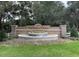 Stone Victoria Oaks entrance featuring a tiered water fountain with lush, mature landscaping at 168 Victoria Oaks Blvd, Deland, FL 32724