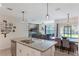 View of the kitchen with island seating, opening up to the living and dining areas at 168 Victoria Oaks Blvd, Deland, FL 32724