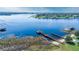 Scenic aerial view of a lakefront property featuring a long pier and a gazebo at 17343 Summer Oak Ln, Clermont, FL 34711