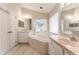 Bathroom featuring a soaking tub, dual vanities, mirrors, and tile flooring at 17343 Summer Oak Ln, Clermont, FL 34711