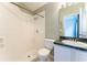 Well-lit bathroom featuring a white tiled walk-in shower and vanity with green marble countertop at 17343 Summer Oak Ln, Clermont, FL 34711