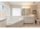 Bright bathroom featuring a large soaking tub, vanity with sink, and a window with natural light at 17343 Summer Oak Ln, Clermont, FL 34711