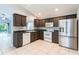 Well-lit kitchen with tile flooring, stainless steel refrigerator and white appliances at 17343 Summer Oak Ln, Clermont, FL 34711