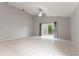 Open living room featuring tile flooring, neutral walls, and sliding glass doors at 17343 Summer Oak Ln, Clermont, FL 34711