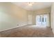 Carpeted bedroom with neutral walls and a glass slider to a covered patio area at 17343 Summer Oak Ln, Clermont, FL 34711