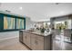 A kitchen island with grey cabinets and a view to a living and dining area at 1861 Walnut Creek Dr, Kissimmee, FL 34744