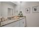 Well-lit bathroom with granite counters, a large mirror, and decorative wall art at 1865 Walnut Creek Dr, Kissimmee, FL 34744