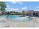 Scenic water fountain feature in community pool, enhanced by mature palms, umbrellas and poolside seating at 1865 Walnut Creek Dr, Kissimmee, FL 34744