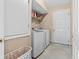 Practical laundry room with modern washer and dryer, storage shelves, and tile floors at 1879 Grey Fox Dr, Lakeland, FL 33810