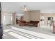 Open-concept living room featuring leather sofas, a ceiling fan, and abundant natural light from the front entrance at 1879 Grey Fox Dr, Lakeland, FL 33810