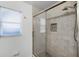 Tiled shower with glass door and a bright window at 1890 Twin Lake Dr, Gotha, FL 34734