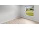 Neutral bedroom with light wood floors and a window view of the green lawn at 1890 Twin Lake Dr, Gotha, FL 34734