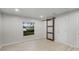 Bedroom featuring wood-look floors, a window, a sliding barn door and a standard door at 1890 Twin Lake Dr, Gotha, FL 34734