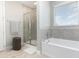 Bathroom features a modern tub, walk-in shower with glass doors, and a window at 204 Pinecrest Rd, Mount Dora, FL 32757