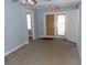 Bedroom with carpeted flooring, a door to the exterior, and a window to the side at 204 S Center St, Eustis, FL 32726