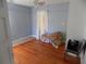 A bedroom featuring hardwood floors, a ceiling fan, and blue painted walls at 204 S Center St, Eustis, FL 32726