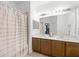 Well-lit bathroom featuring a double vanity, neutral tile and a shower with curtain at 20648 Maxim Pkwy Pkwy, Orlando, FL 32833