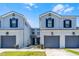 Charming townhomes with two stories, gray paint, black shutters, and attached garages at 20648 Maxim Pkwy Pkwy, Orlando, FL 32833