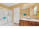 Bathroom featuring double sinks, a shower with glass doors, and neutral decor at 2233 Tulip Valley Pt, Sanford, FL 32771