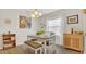 Bright dining area with a wooden table, white chairs, bench seating, and stylish decor at 2233 Tulip Valley Pt, Sanford, FL 32771