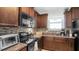 Well-lit kitchen with dark cabinets, stainless steel appliances, and mosaic backsplash at 2233 Tulip Valley Pt, Sanford, FL 32771