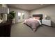 Bright bedroom with a tufted headboard bed, neutral decor, and a window overlooking a lush green landscape at 2318 White Tail St, Davenport, FL 33837