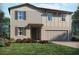 Two-story home featuring beige siding, a two-car garage, and well-maintained landscaping with colorful flowering shrubs at 2318 White Tail St, Davenport, FL 33837