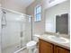 Tiled bathroom featuring walk-in shower with glass door, a sink and a toilet at 250 Ryans Ridge Ave, Eustis, FL 32726