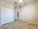 Comfortable bedroom with neutral walls, tiled floors, ceiling fan, and a double door closet at 250 Ryans Ridge Ave, Eustis, FL 32726