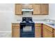 Close-up of the electric range and counter with wooden cabinets in the kitchen at 250 Ryans Ridge Ave, Eustis, FL 32726