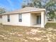 Rear view showcasing stucco exterior, back porch, and grassy backyard at 250 Ryans Ridge Ave, Eustis, FL 32726